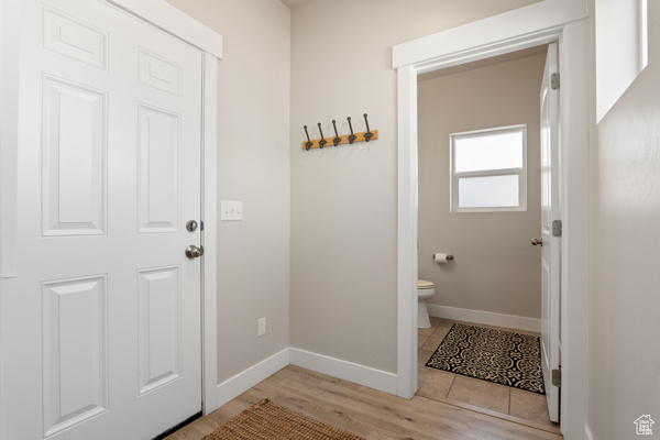 Doorway to outside with baseboards and light wood-style floors