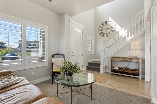 Living area featuring stairs, plenty of natural light, and baseboards