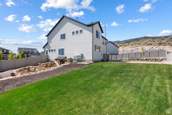 Back of house with a mountain view and cooling unit