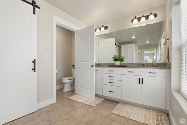 Full bath featuring toilet, tile patterned flooring, vanity, and baseboards