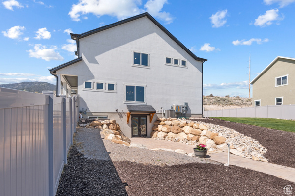 Back of house featuring fence and central AC unit