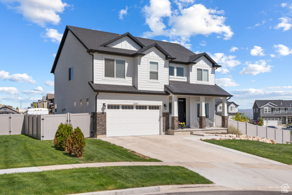 View of front of house with a gate, a garage, concrete driveway, a residential view, and covered porch