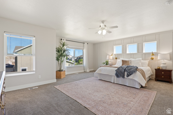 Carpeted bedroom with baseboards and ceiling fan