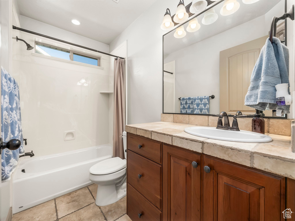 Bathroom featuring shower / bath combo with shower curtain, toilet, and vanity
