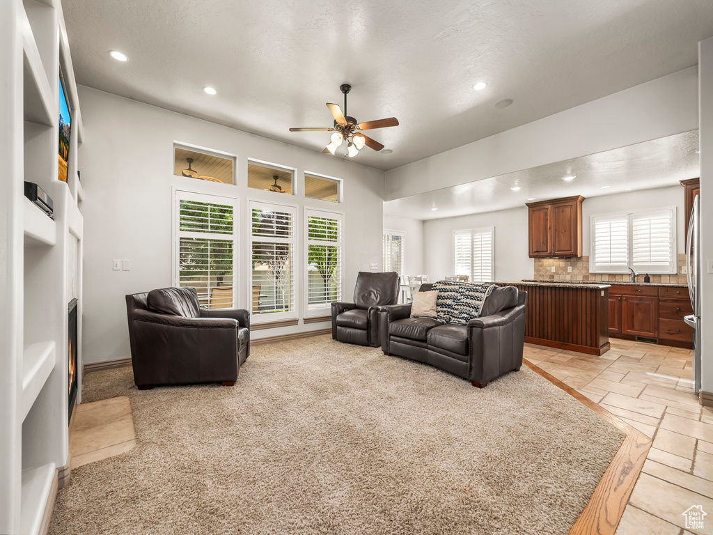 Living room with recessed lighting, ceiling fan, and stone tile flooring