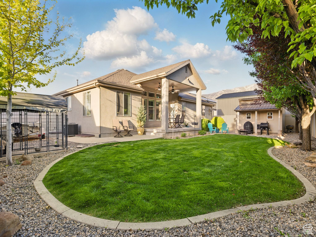 Back of property with a ceiling fan, a patio area, central AC, and stucco siding