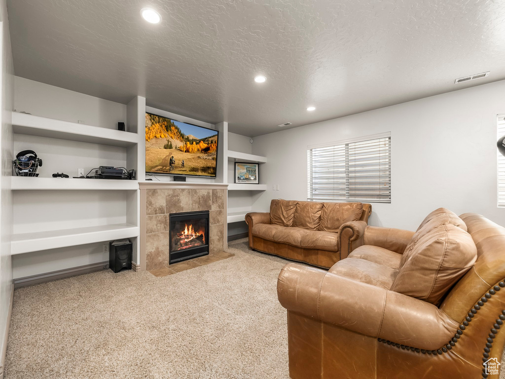 Living area featuring recessed lighting, carpet flooring, a fireplace, and a textured ceiling