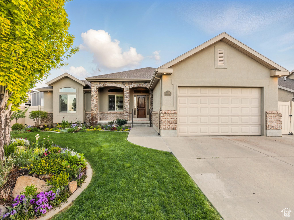View of front of house featuring a garage, driveway, stucco siding, and roof with shingles