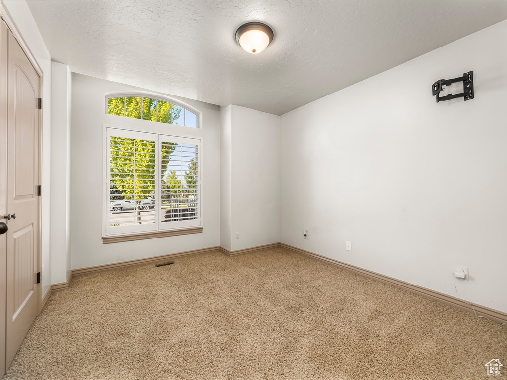 Spare room featuring carpet flooring and baseboards