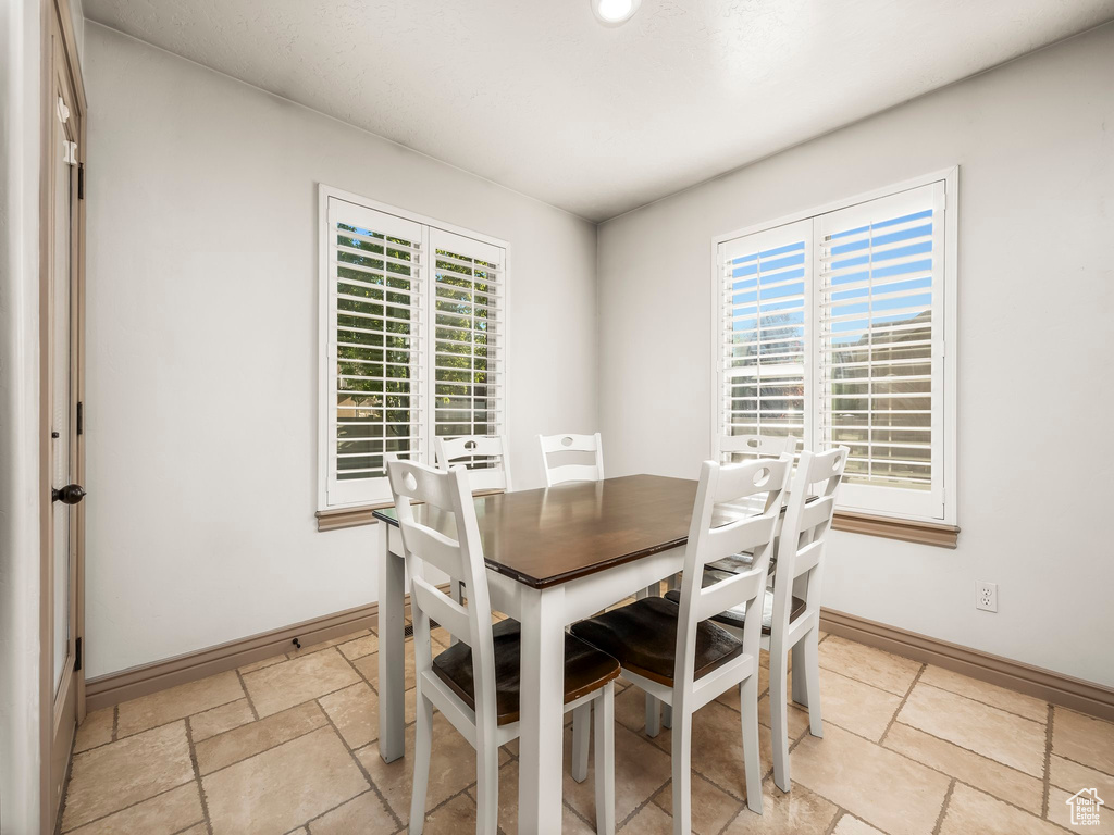 Dining area featuring baseboards and light stone finish floors