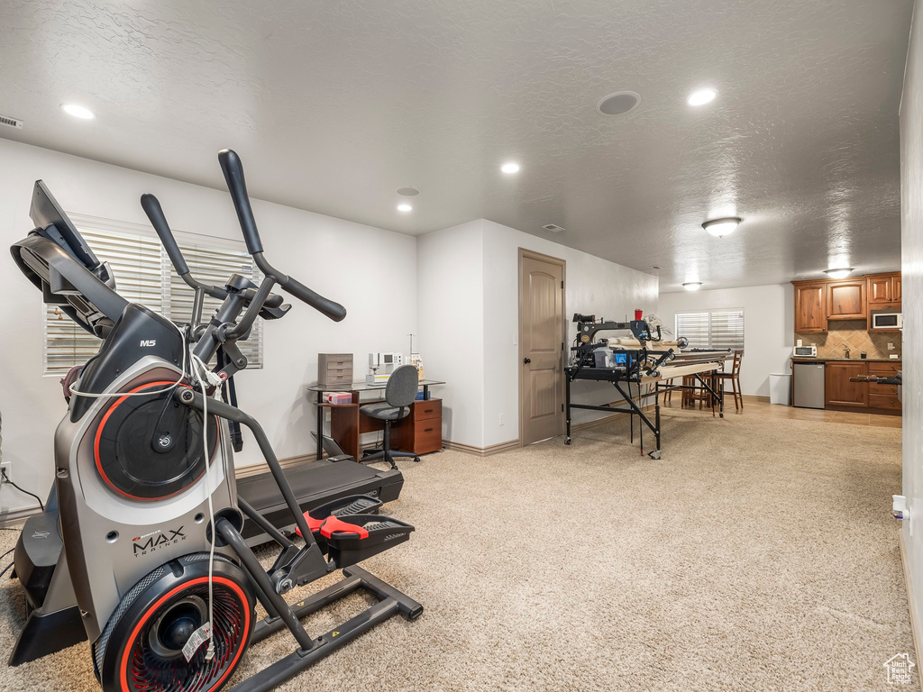 Workout room with a textured ceiling, recessed lighting, and baseboards