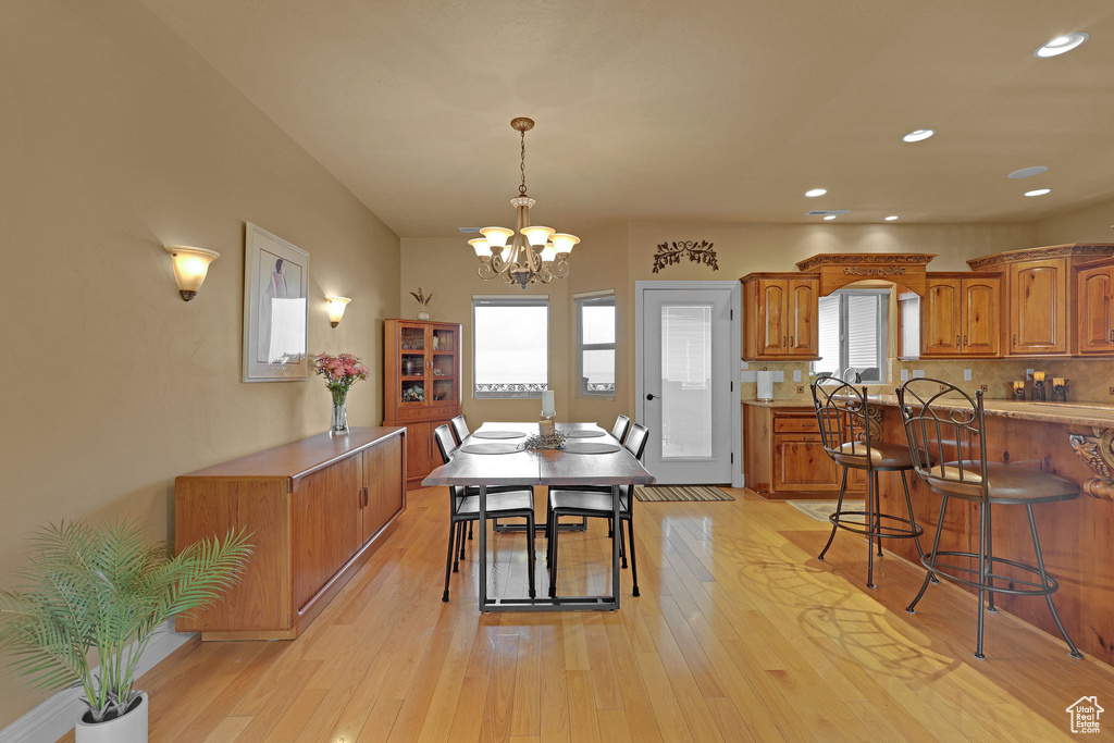 Dining area with a chandelier, light wood-style floors, and recessed lighting