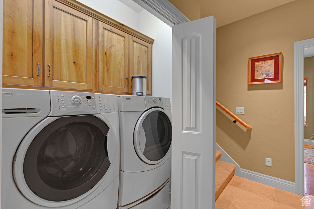 Washroom with separate washer and dryer, tile patterned floors, and baseboards