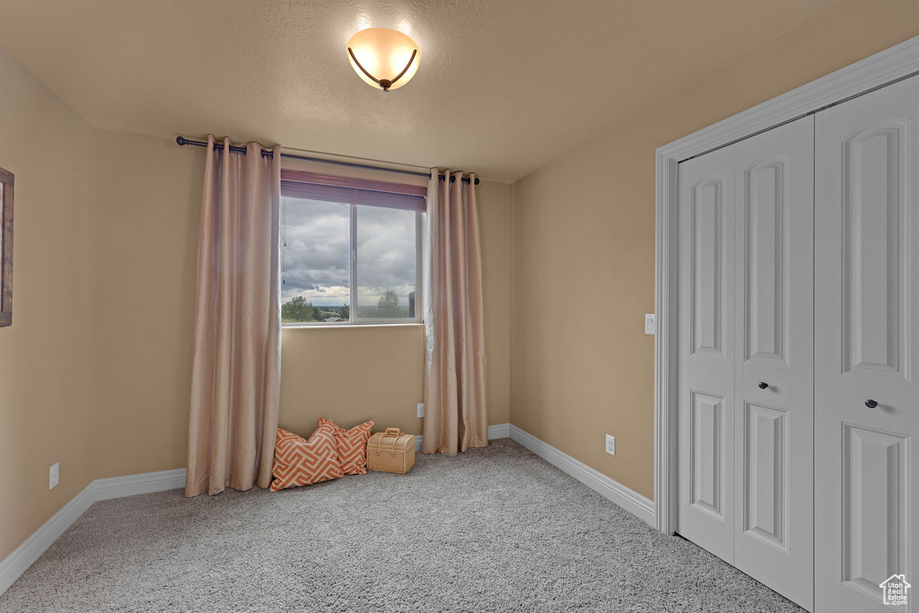 Unfurnished bedroom with carpet, baseboards, and a closet