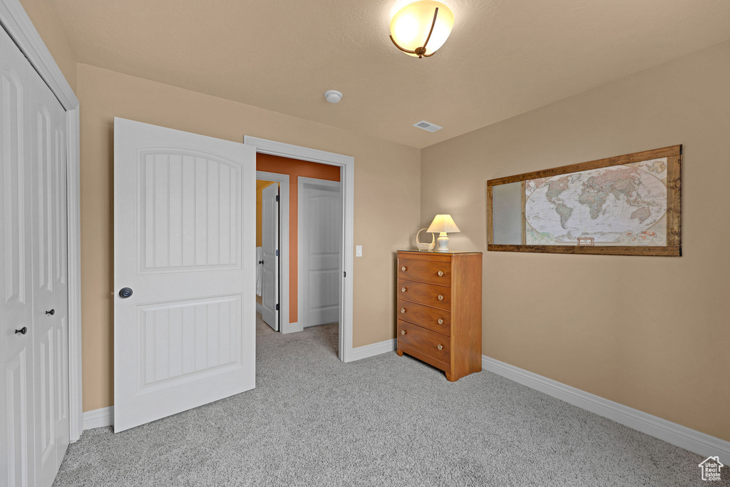 Carpeted bedroom featuring a closet and baseboards