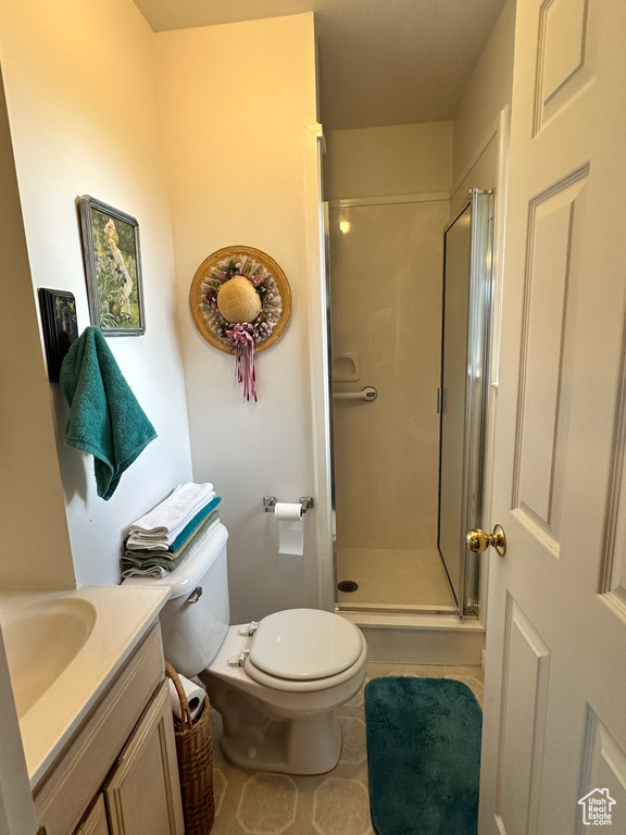 Full bath with a shower stall, vanity, toilet, and tile patterned flooring