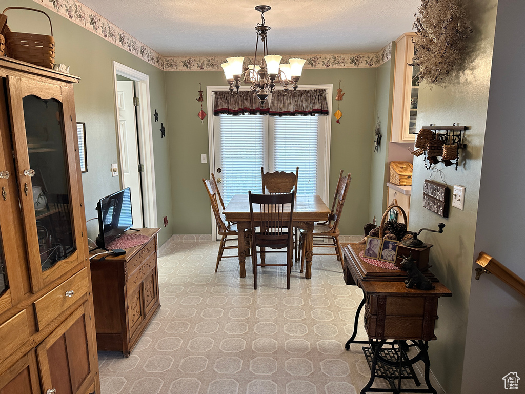 Dining area with a chandelier, light floors, and baseboards