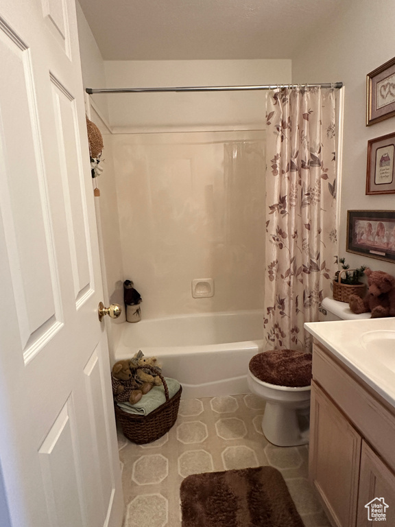 Bathroom with shower / bath combo, toilet, and vanity