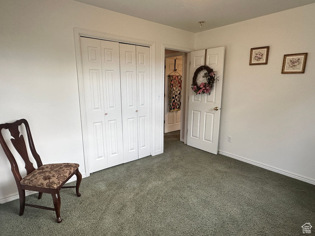 Living area featuring dark carpet and baseboards