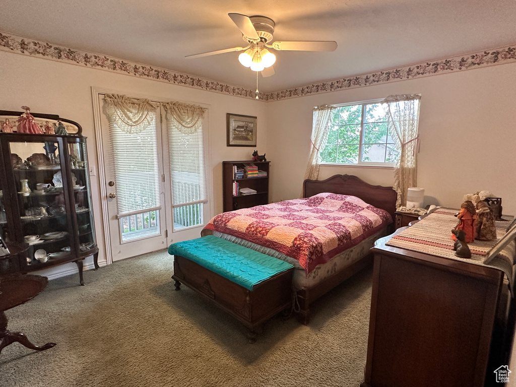 Carpeted bedroom with access to outside and ceiling fan