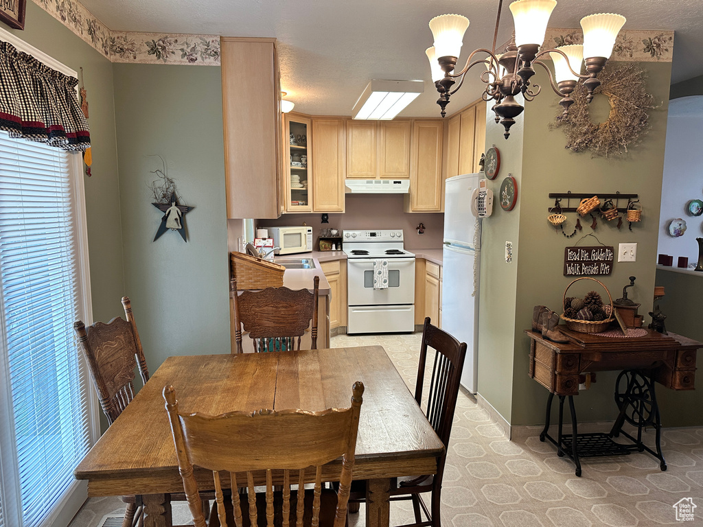 Dining area featuring a chandelier and baseboards
