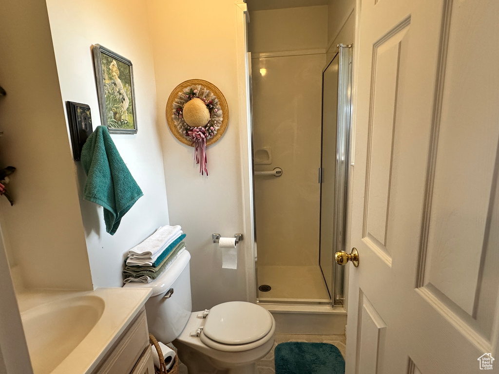 Full bathroom featuring a stall shower, vanity, and toilet