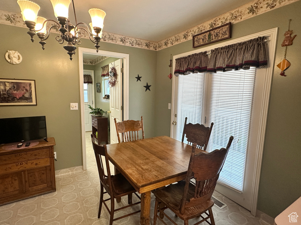 Dining area featuring a chandelier, baseboards, and light flooring