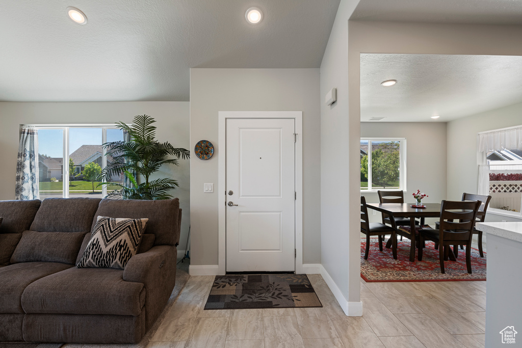 Entryway with healthy amount of natural light, baseboards, and recessed lighting
