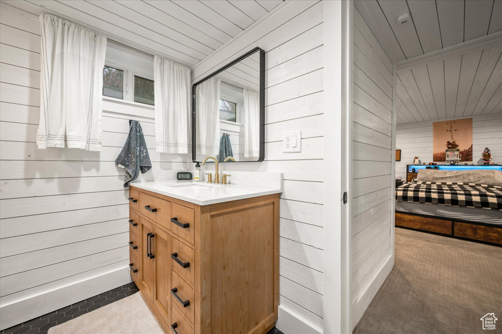 Bathroom with wooden walls, wooden ceiling, and vanity