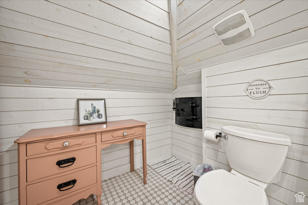 Bathroom featuring wood walls and toilet