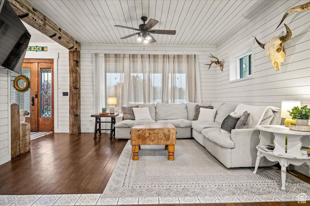 Living room with wooden walls, wooden ceiling, hardwood / wood-style flooring, and ceiling fan