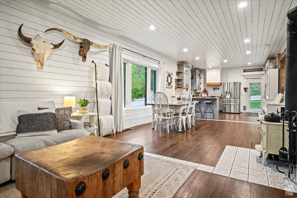 Living room with recessed lighting, a wood stove, and dark wood-style floors