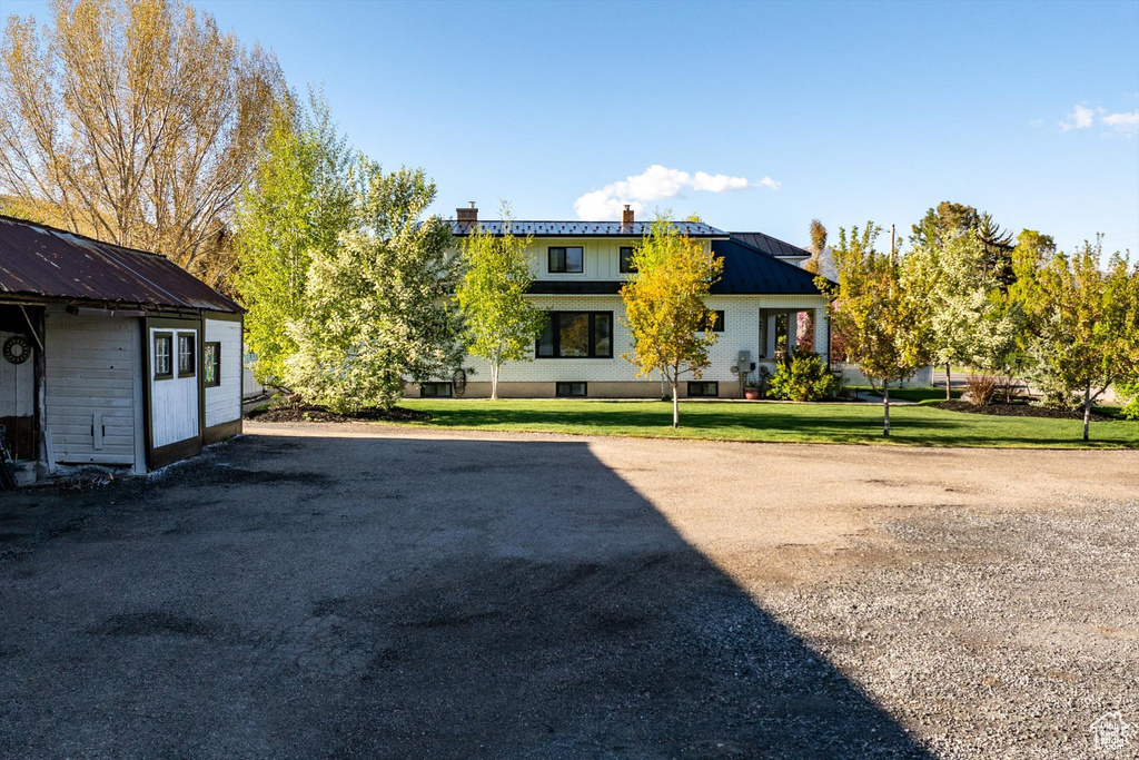 Back of house featuring metal roof and a lawn