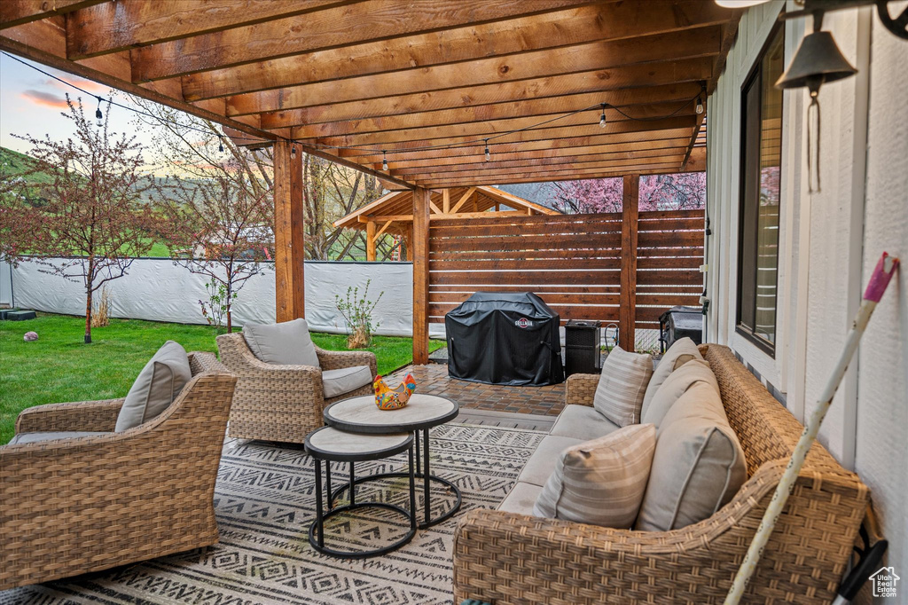 View of patio with grilling area, a fenced backyard, and a pergola