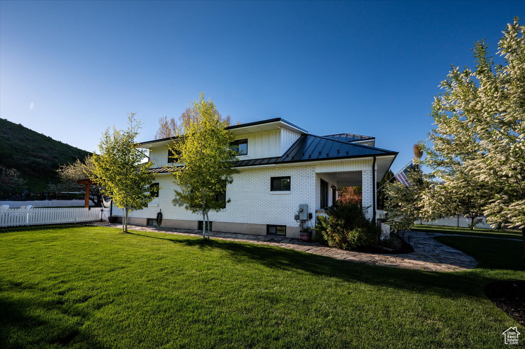 Rear view of property with a standing seam roof, metal roof, and brick siding