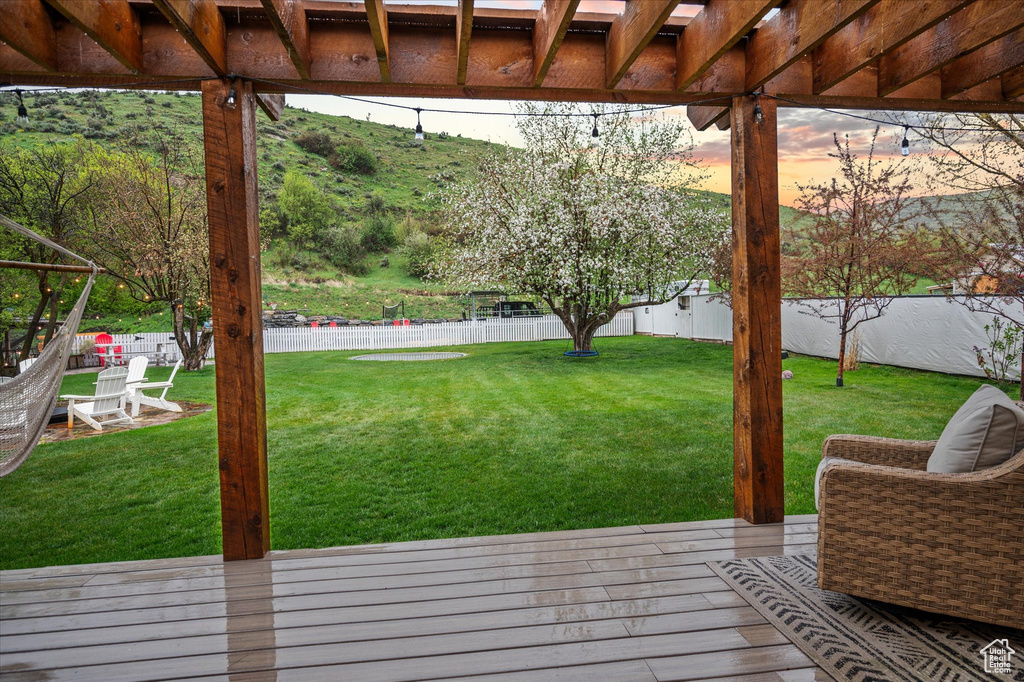 Deck at dusk featuring a pergola