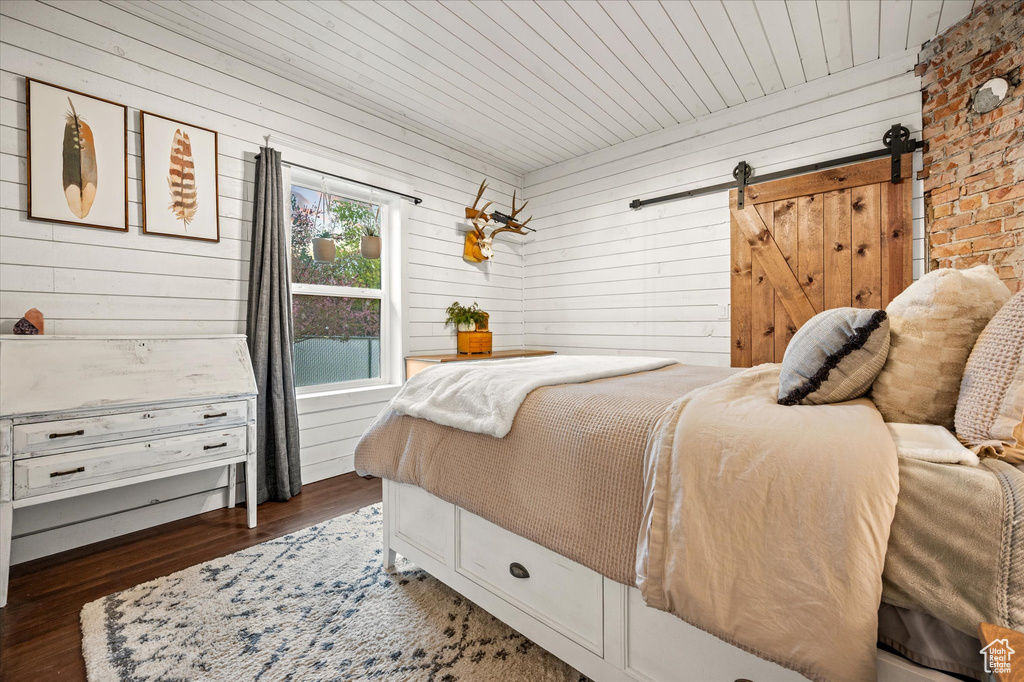 Bedroom with wood walls and wood finished floors