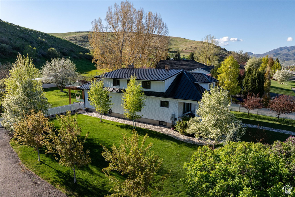 View of property exterior with a standing seam roof, metal roof, a chimney, and a mountain view