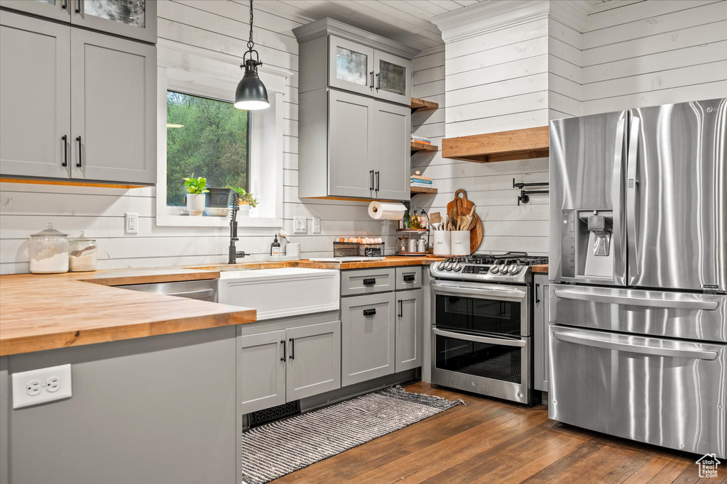 Kitchen featuring wood counters, appliances with stainless steel finishes, and gray cabinets