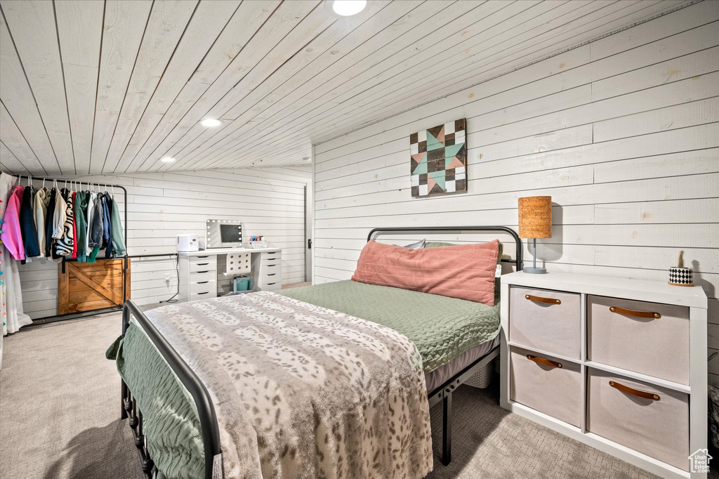 Carpeted bedroom featuring wood ceiling, recessed lighting, and wood walls