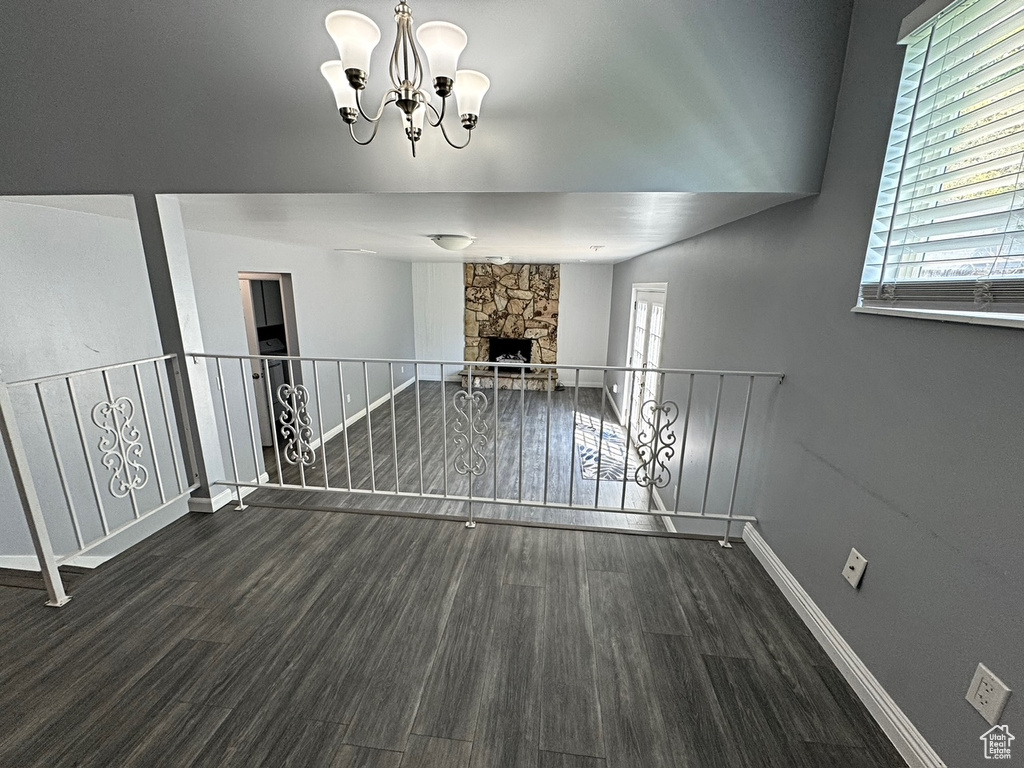 Unfurnished living room with wood finished floors, plenty of natural light, baseboards, and a fireplace