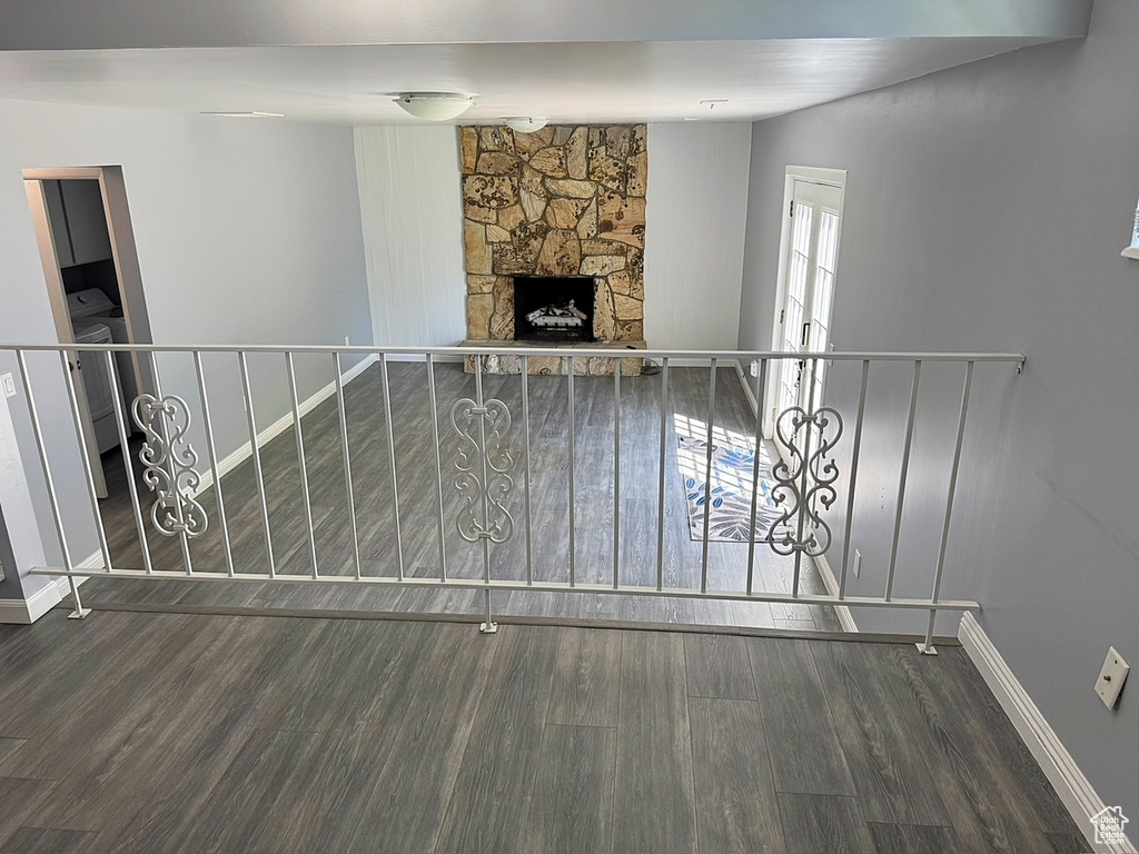 Unfurnished living room featuring wood finished floors, a fireplace, and baseboards