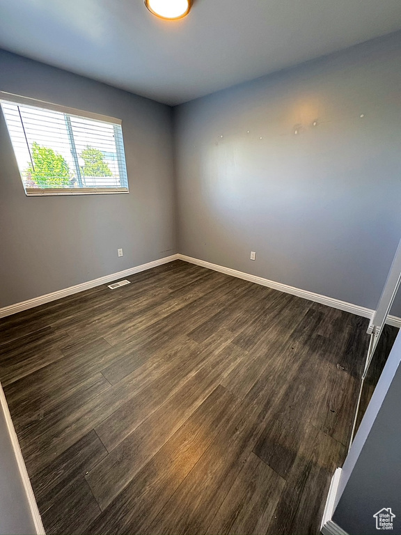 Unfurnished room with dark wood-style flooring and baseboards