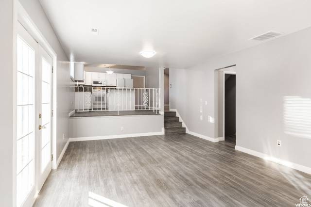 Spare room with wood finished floors, baseboards, and stairs