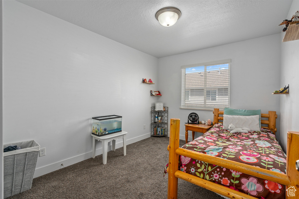 Carpeted bedroom with baseboards and a textured ceiling