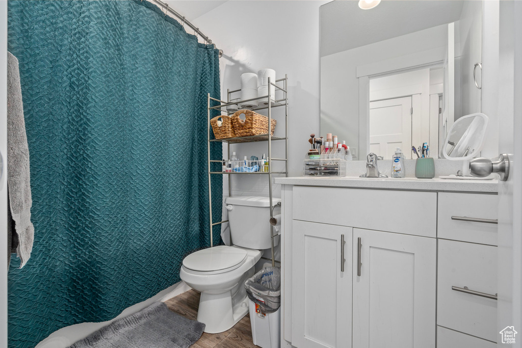 Bathroom featuring wood finished floors, toilet, and vanity