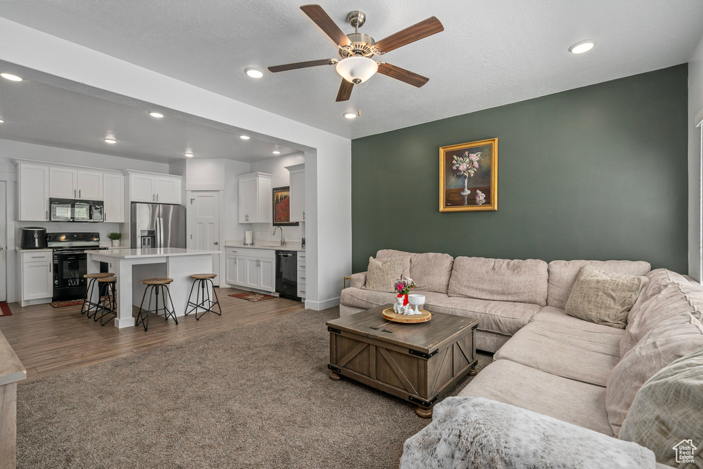 Living area featuring recessed lighting, wood finished floors, ceiling fan, and baseboards