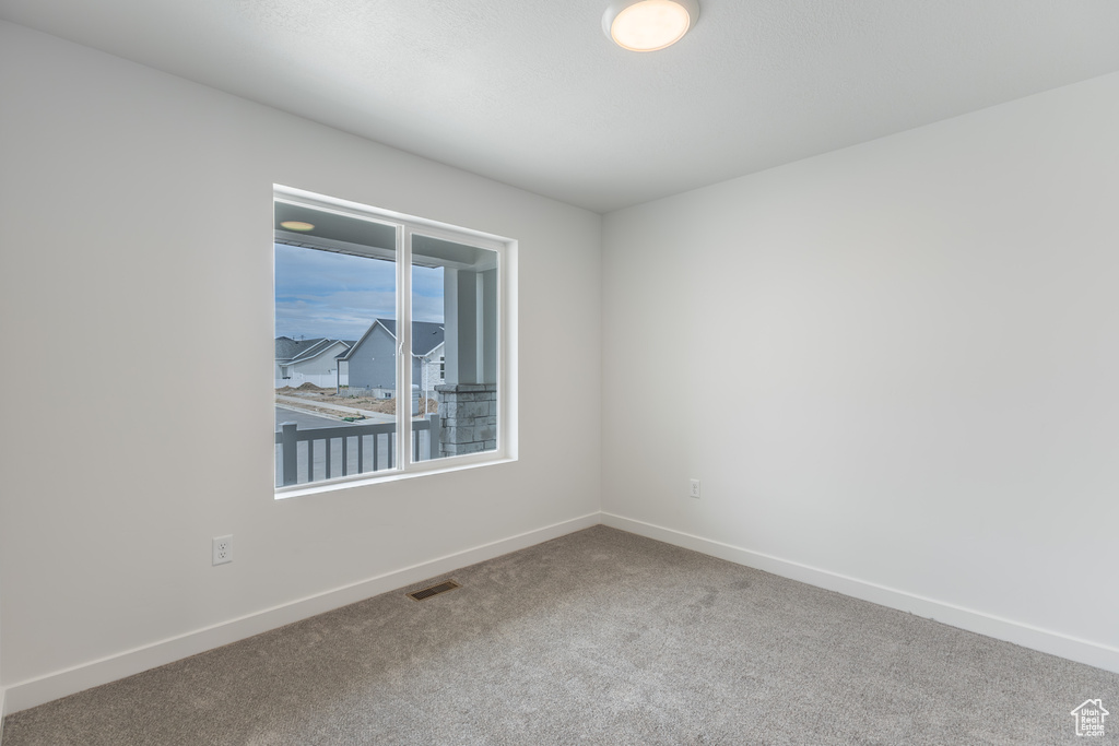 Spare room featuring carpet and baseboards