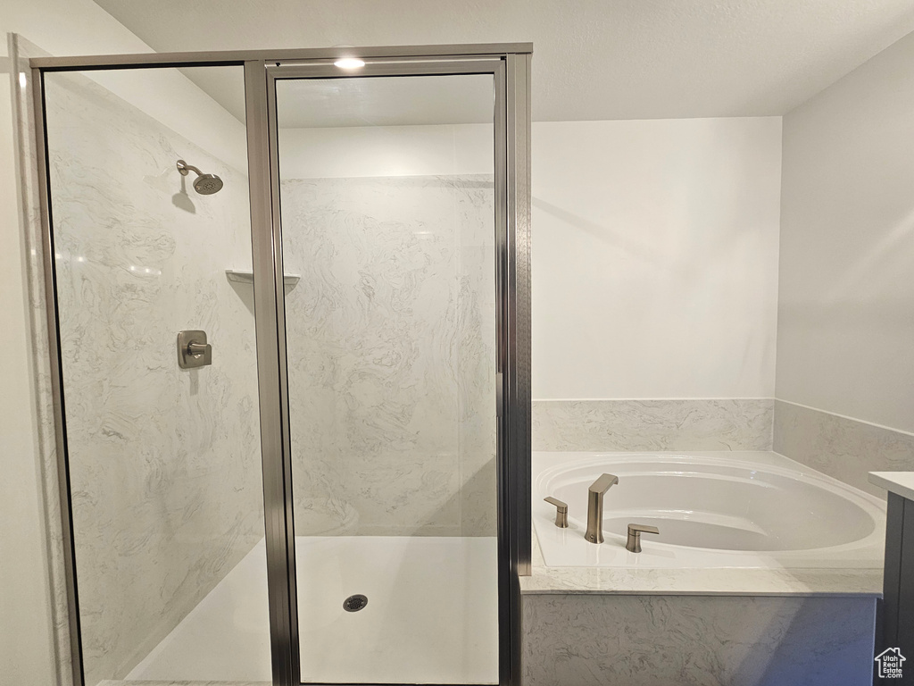 Bathroom with a shower stall and a garden tub