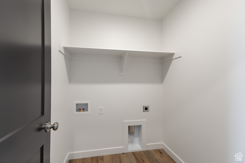 Laundry room with hookup for an electric dryer, wood finished floors, hookup for a washing machine, and baseboards